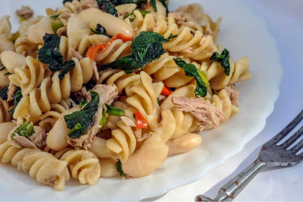 pasta salad on a white plate with a fork